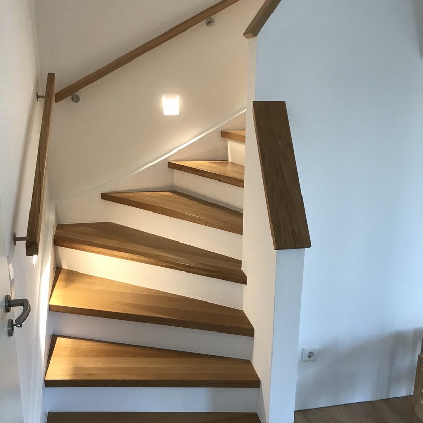 Treppenhaus im modernen Stil mit wei&szlig;en und holzfarbenden Stufen