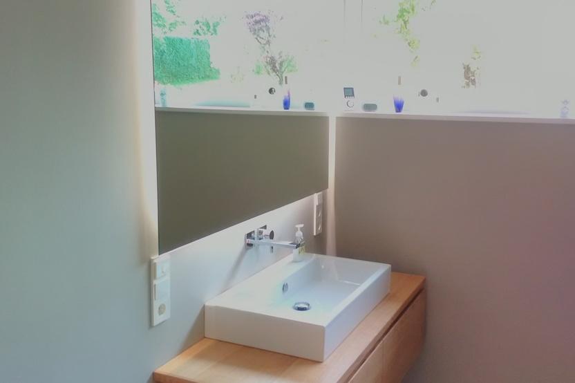 Waschebeckenunterschrank aus Holz unter Spiegel mit eckigem Waschebecken