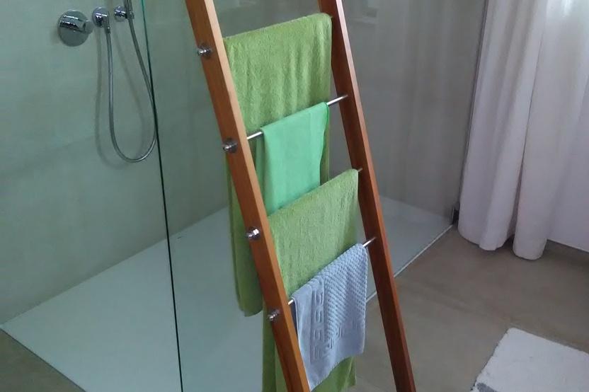 Handtuchhalter in Leiteroptik aus Holz, gelehnt an Duschkabine