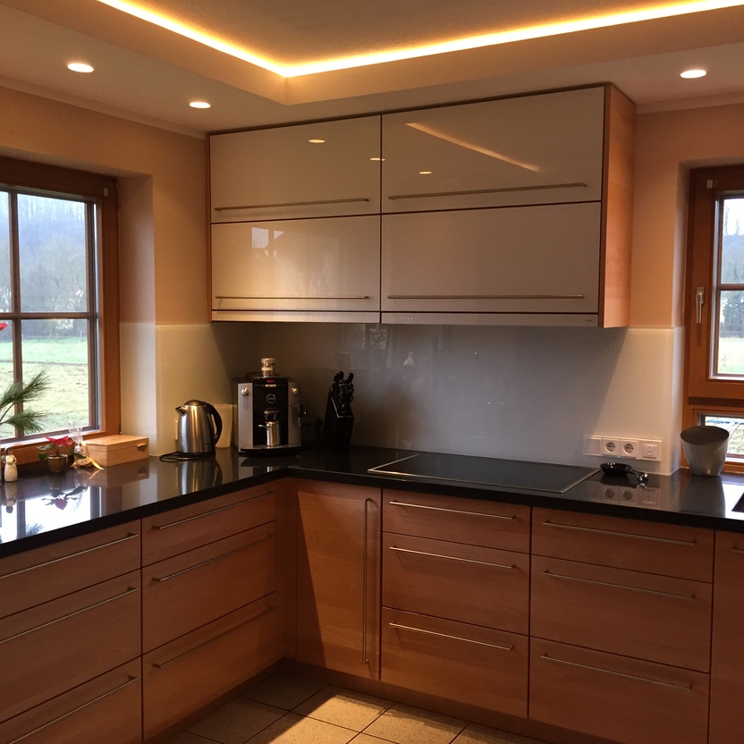 Helle, maßgefertigte Küchenmöbel mit Oberlicht und großem Fenster mit Blick auf eine ländliche Landschaft.