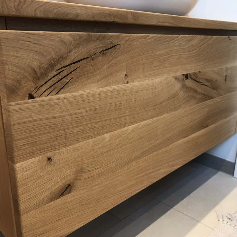 Front eines ma&szlig;gefertigten Badm&ouml;bels aus massivem Holz mit nat&uuml;rlicher Maserung und Schublade