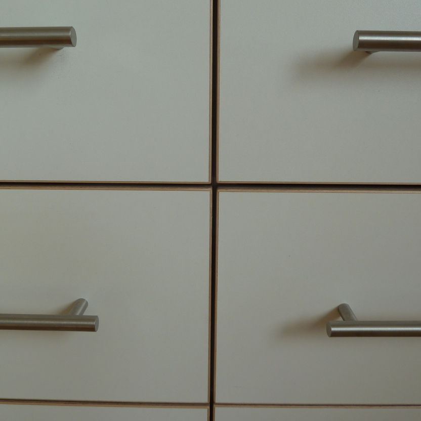 Detailaufnahme weißer Schubladen mit modernen Metallgriffen, Teil eines maßgefertigten Büromöbels nach Maß