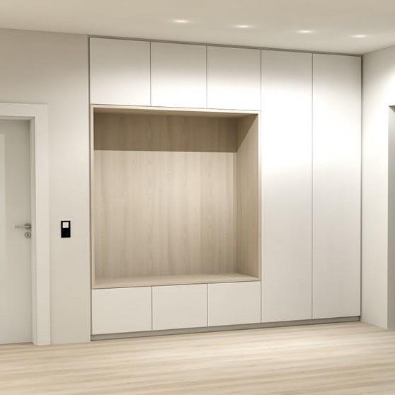 Ein geräumiger, heller Raum mit einem großen, maßgefertigten Einbauschrank neben einer weißen Tür und einer dunklen Eingangstür.