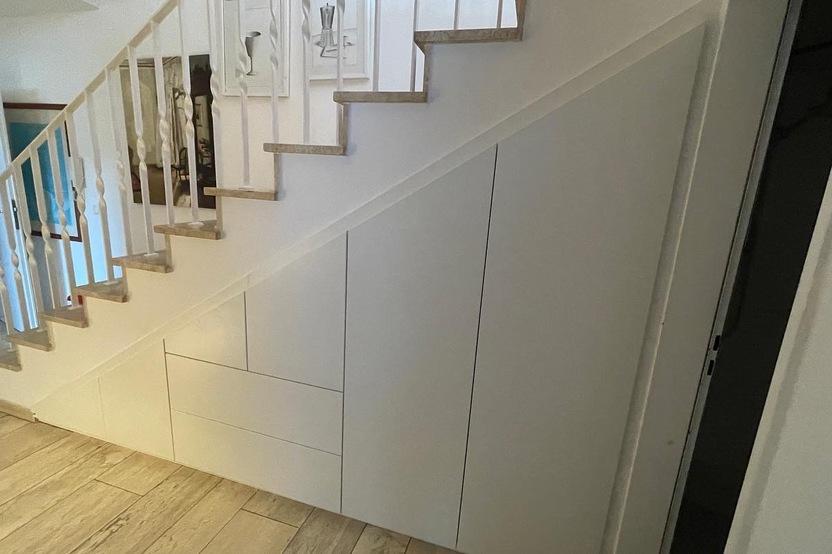 Individueller Einbauschrank unter Treppe mit weißen Fronten
