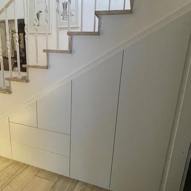 Individueller Einbauschrank unter Treppe mit weißen Fronten