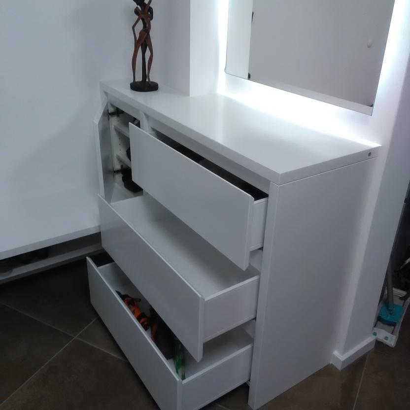ALT-Beschreibung: Offene Schubladen eines weißen Einbauschranks nach Maß, mit einem dekorativen Objekt oben auf dem Schrank.