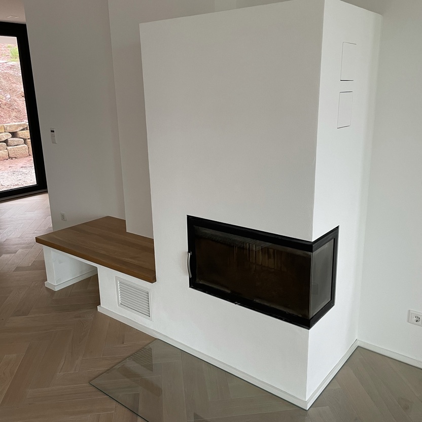 Ein elegantes Wohnzimmer nach Maß mit einem eingebauten Kamin und einer Holzbank in einem minimalistischen Design.