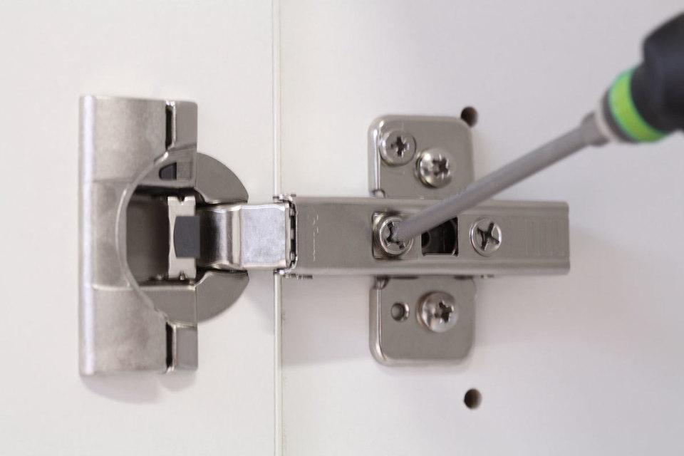 Detailaufnahme eines mit Schraubendreher nachjustierbaren Türscharniers