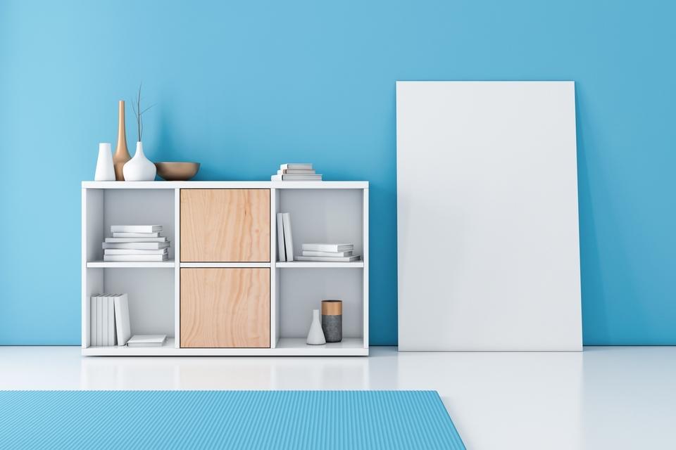 Blaue Wand und weißes Regal mit verschiedenen Fächern